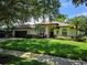 Charming single-story home featuring a well-manicured lawn, lush landscaping, and a welcoming front entrance at 9491 Wickham Way, Orlando, FL 32836