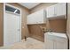 Practical laundry room with storage cabinets and a sink, perfect for managing household chores efficiently at 9491 Wickham Way, Orlando, FL 32836