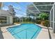 A sparkling screened-in pool for swimming and relaxing with lush tropical landscaping at 9491 Wickham Way, Orlando, FL 32836