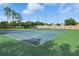 Well-maintained blue tennis courts surrounded by green space in a sunny community at 9491 Wickham Way, Orlando, FL 32836