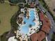Aerial view of community pool area featuring a slide, splash pad, various pools, and lush landscaping at 4111 Oaktree Dr, Davenport, FL 33837
