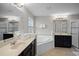A spacious bathroom features dual sinks, dark cabinetry, a soaking tub, a separate shower, and tile flooring at 4111 Oaktree Dr, Davenport, FL 33837