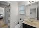 Bathroom with neutral walls, a black vanity, and a window with blinds, plus shower/tub combo at 4111 Oaktree Dr, Davenport, FL 33837