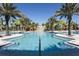 Sprawling community pool area with waterslide, palm trees, lounge chairs, and shallow entrance for easy access at 4111 Oaktree Dr, Davenport, FL 33837