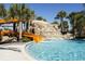 Community pool featuring a waterslide and rock waterfall feature that offers hours of fun for all ages at 4111 Oaktree Dr, Davenport, FL 33837