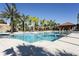 Large community pool with palm trees, cabanas, ample seating, and a pool house for relaxing days at 4111 Oaktree Dr, Davenport, FL 33837