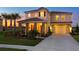 Inviting two-story home with a two-car garage and well-manicured landscaping at sunset at 4111 Oaktree Dr, Davenport, FL 33837