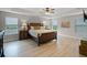 This main bedroom has a tray ceiling, wood-look floors, and a large bed with views from multiple windows at 4111 Oaktree Dr, Davenport, FL 33837