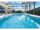 A large screened-in pool features a sun shelf, hot tub, and safety fence, perfect for outdoor fun and relaxation at 4111 Oaktree Dr, Davenport, FL 33837