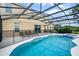 A large screened-in pool features a sun shelf, hot tub, and safety fence, perfect for outdoor fun and relaxation at 4111 Oaktree Dr, Davenport, FL 33837