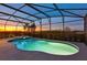 Sparkling screened-in pool and hot tub with sunset views, perfect for relaxation at 4111 Oaktree Dr, Davenport, FL 33837