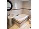 Bathroom with a pedestal sink, jacuzzi tub with tile surround, and decorative mirror at 1000 S Semoran Blvd # 415, Winter Park, FL 32792