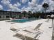 Community pool with lounge chairs and palm trees, offering a serene outdoor experience at 1000 S Semoran Blvd # 415, Winter Park, FL 32792