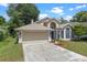 Inviting home showcasing well-maintained lawn, two-car garage, and a welcoming front entrance at 1021 Piedmont Oaks Dr, Apopka, FL 32703