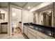 Well-lit bathroom with a spacious vanity, black granite countertop, and a walk-in closet at 1055 Kensington Park Dr # 203, Altamonte Springs, FL 32714