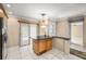 Open concept kitchen featuring wood cabinetry, black countertops, and tiled floors at 1055 Kensington Park Dr # 203, Altamonte Springs, FL 32714