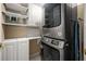 Functional laundry area equipped with a stacked washer and dryer set, storage shelves, and ample counter space at 1055 Kensington Park Dr # 203, Altamonte Springs, FL 32714