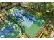 Aerial view of tennis courts showing green and blue surfaces surrounded by lush landscaping at 1055 Kensington Park Dr # 203, Altamonte Springs, FL 32714