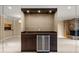Close-up of the wet bar showcasing the marble countertop, wine cooler, and mirrored backdrop at 1055 Kensington Park Dr # 203, Altamonte Springs, FL 32714