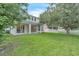 Expansive backyard featuring lush grass, a white picket fence, a large tree, and an extended covered patio at 1067 Chatham Break St, Orlando, FL 32828