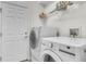 Modern laundry room with a side-by-side washer and dryer and storage shelving at 1067 Chatham Break St, Orlando, FL 32828
