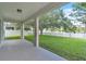 Covered patio with views of the landscaped backyard, white picket fence, lake, and a fountain at 1067 Chatham Break St, Orlando, FL 32828