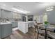 Modern kitchen features gray cabinets, a large island with seating, and a stylish light fixture over the dining table at 111 Woodstream Ct Ct, Maitland, FL 32751