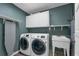Functional laundry room with modern washer and dryer units, a utility sink, and practical storage solutions at 111 Woodstream Ct Ct, Maitland, FL 32751
