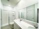 Bright bathroom featuring double sinks, quartz counters, large mirror, and glass enclosed shower at 1147 Pomelo St, Davenport, FL 33837