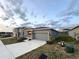 Single-story house with a two-car garage, a concrete driveway, and green front lawn at 1147 Pomelo St, Davenport, FL 33837
