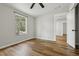 A naturally lit bedroom with wood flooring and a window overlooking the green trees at 1235 Arapaho Trl, Geneva, FL 32732