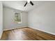 A serene bedroom with wood floors and a bright window overlooking lush trees at 1235 Arapaho Trl, Geneva, FL 32732