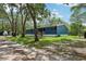 Inviting blue single-story home showcasing a well-manicured lawn and a covered front porch at 1235 Arapaho Trl, Geneva, FL 32732
