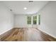 Open-concept living room featuring laminate floors and an abundance of natural light through large windows at 1235 Arapaho Trl, Geneva, FL 32732