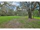 Serene property featuring verdant grass and a canopy of mature trees at 1235 Arapaho Trl, Geneva, FL 32732