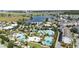 Stunning aerial view of community pools, amenities, lush landscaping, and neighboring lake at 13755 Benavente Ave, Orlando, FL 32827