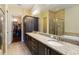 Granite countertops and dark wood cabinetry add elegance to this bathroom with walk-in closet and glass-enclosed shower at 13755 Benavente Ave, Orlando, FL 32827