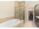 Bathroom featuring a walk-in shower, soaking tub, and walk-in closet at 13755 Benavente Ave, Orlando, FL 32827