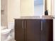 Bathroom featuring dark cabinets, granite countertop, sink and faucet, toilet, and beige wall tile at 13755 Benavente Ave, Orlando, FL 32827