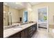 Bathroom with double vanity, large mirror and separate shower and tub at 13755 Benavente Ave, Orlando, FL 32827