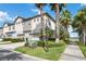 Charming multi-story townhome featuring attached garages, landscaped grounds, and mature palm trees at 13755 Benavente Ave, Orlando, FL 32827