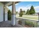 Inviting front porch with stone pavers, pillars, metal railing, and view of lake and trees at 13755 Benavente Ave, Orlando, FL 32827