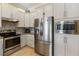 This bright kitchen features stainless steel appliances, white cabinets, and granite countertops at 13755 Benavente Ave, Orlando, FL 32827