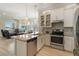 Bright kitchen features granite counters, stainless steel appliances, and an island with a sink at 13755 Benavente Ave, Orlando, FL 32827