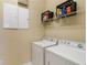 Laundry room with white washer and dryer, wire storage shelf, and closet at 13755 Benavente Ave, Orlando, FL 32827