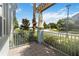 Outdoor patio featuring stone pavers, pillars, metal railing, and view of lake and street at 13755 Benavente Ave, Orlando, FL 32827