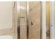 This tiled shower features glass enclosure with a rain shower head and built-in bench at 13755 Benavente Ave, Orlando, FL 32827