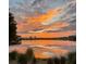 Spectacular sunset over serene lake reflecting vibrant orange and purple hues across the sky at 13755 Benavente Ave, Orlando, FL 32827