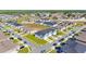Wide aerial view of a neighborhood showcasing modern townhouses with attached garages and community layout at 1471 Mirabella Cir, Davenport, FL 33897