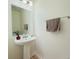 Clean half bathroom featuring a pedestal sink, a large mirror, and modern fixtures at 1471 Mirabella Cir, Davenport, FL 33897
